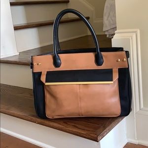 Black and tan tote bag with gold hardware. Purse.